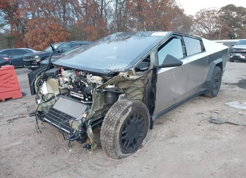Wrecked Tesla Cybertruck with front end damage exposing internal components, needing collision repair