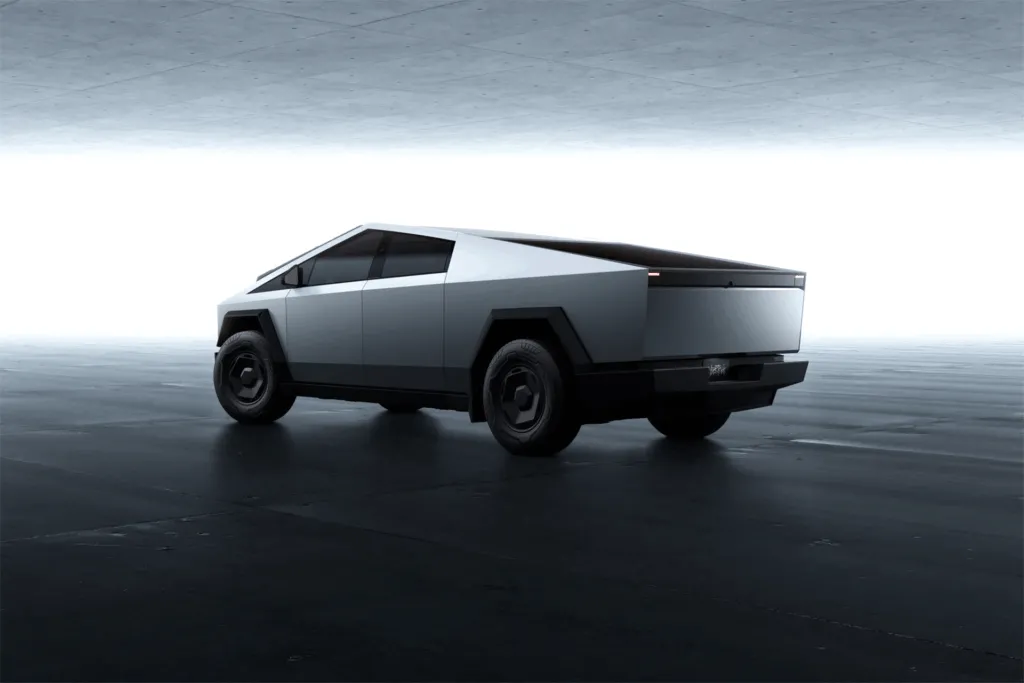 Tesla Cybertruck in stainless steel finish shown from rear three-quarter angle in studio