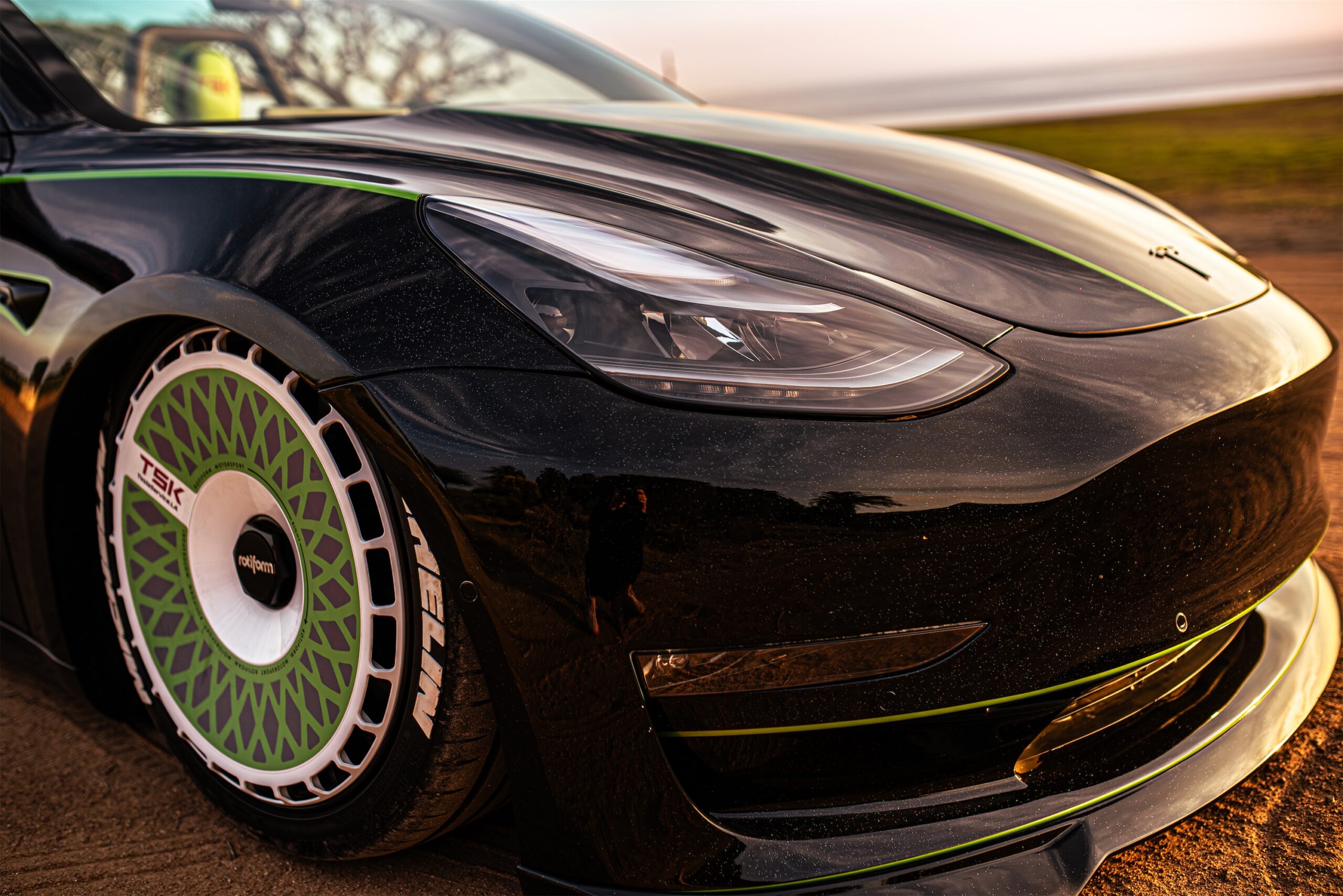 Roofless Tesla project: black Tesla Model 3 front end with green stripes and white Rotiform wheels