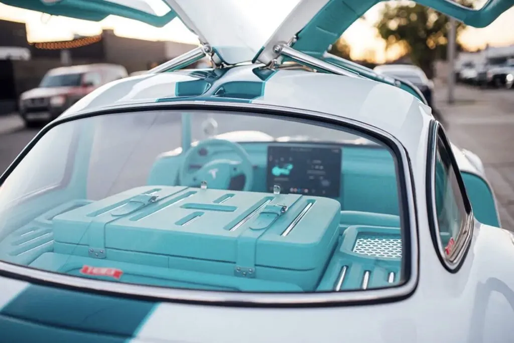 Tesla Gullwing project: teal luggage behind the seats, seen through the rear window