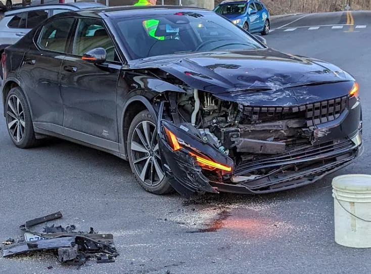 Black Polestar sedan with severe front-end collision damage before repair at TSK