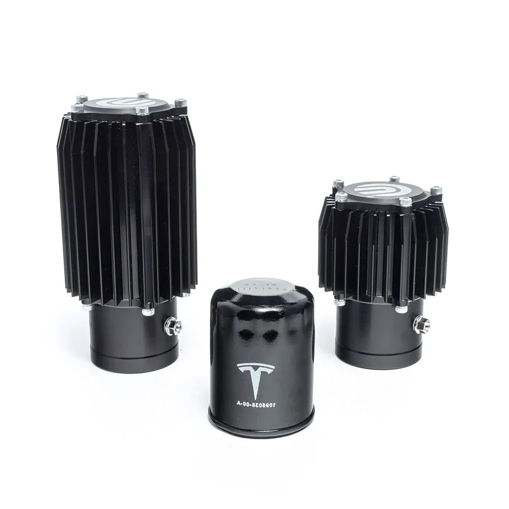 Two finned heat sink components beside a Tesla drive unit reduction gear oil filter