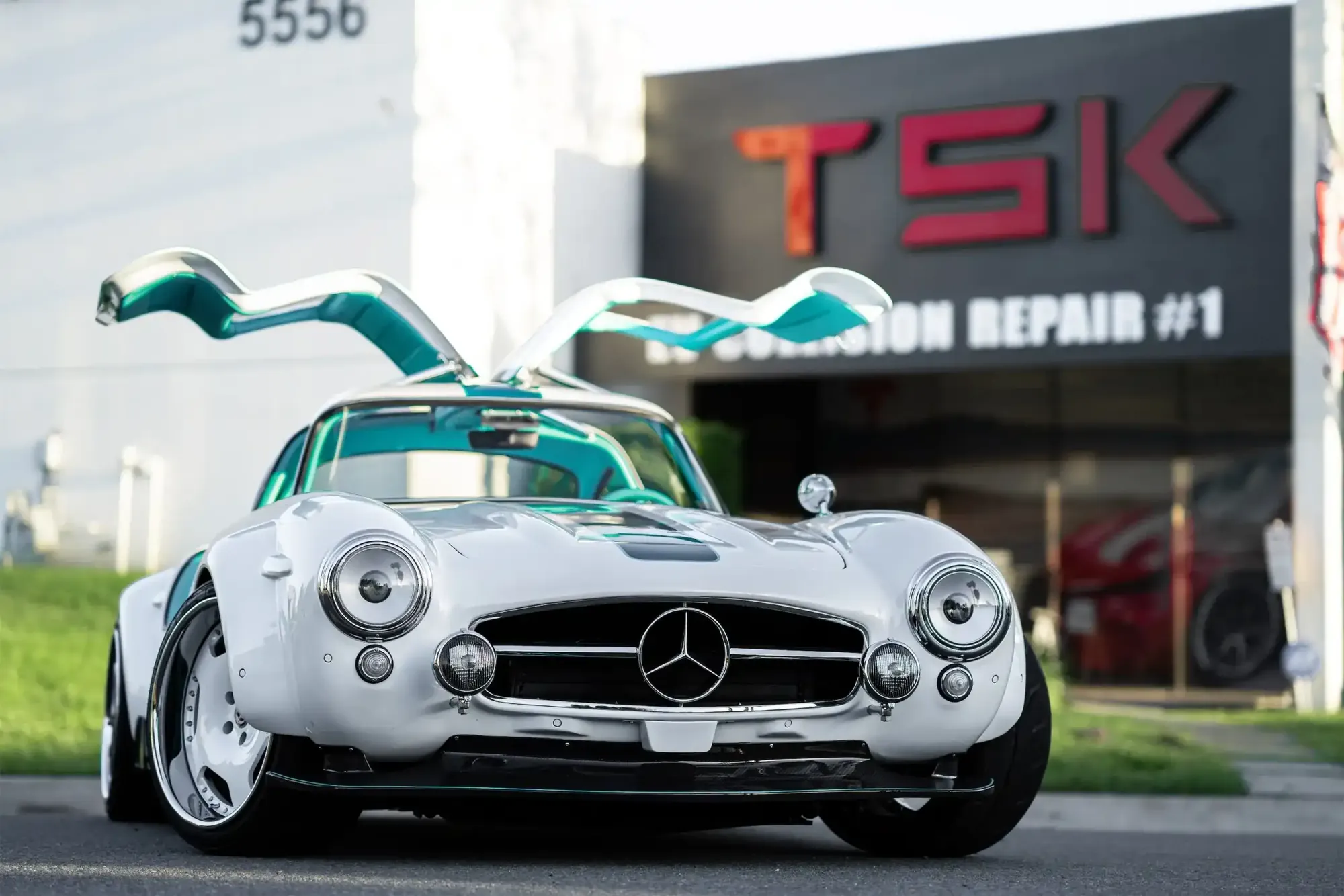 Tesla Gullwing project: white 300SL-style EV with gullwing doors open outside TSK EV Collision Repair