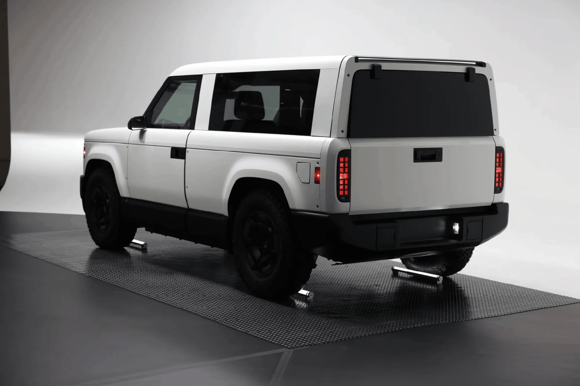 White Slate electric pickup truck rear view in studio, budget EV model 2026
