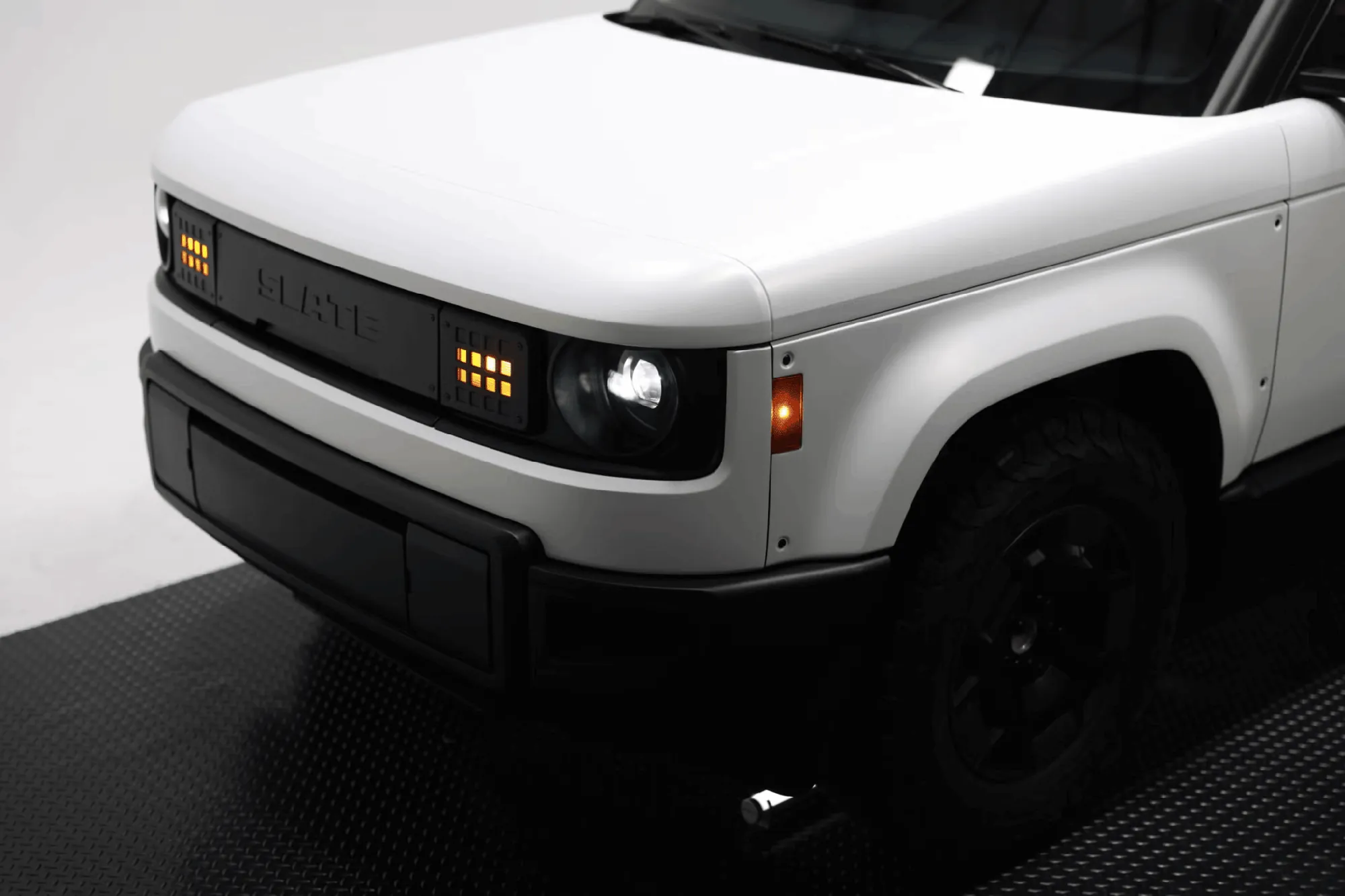 Slate electric pickup truck front end with amber grille lights and headlamp