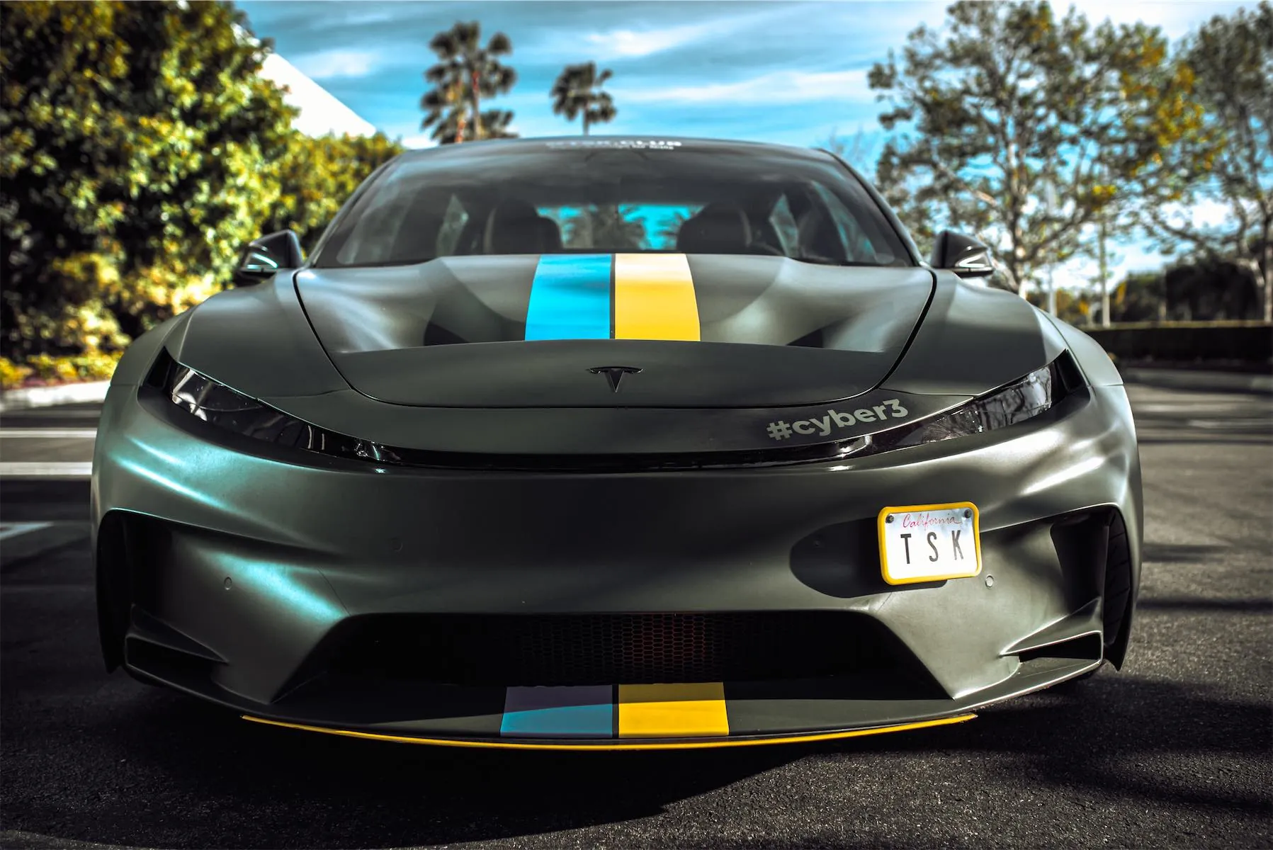 Cyber 3 project: front of the matte green Model 3 widebody with the blue and yellow hood stripe