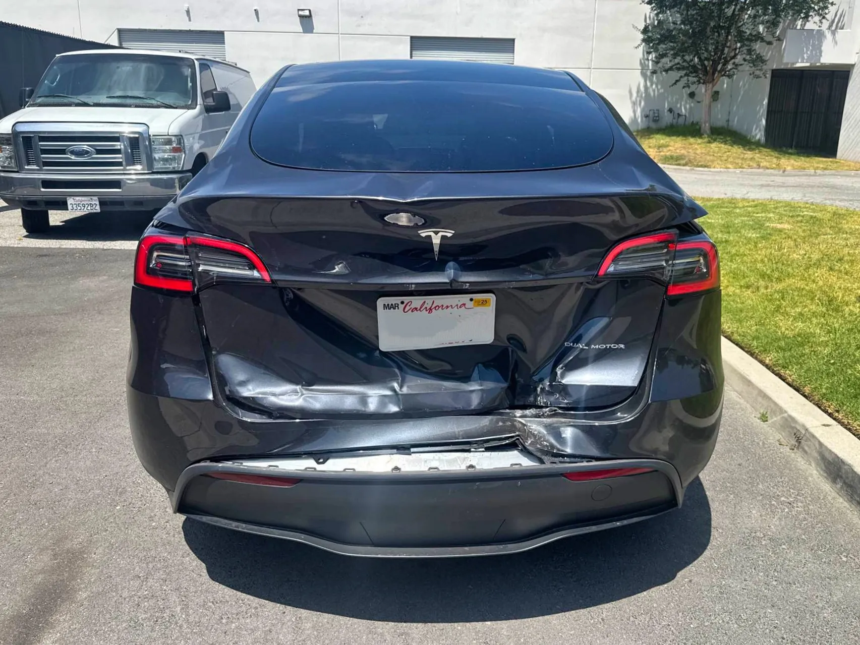 Black Tesla Model Y rear bumper collision damage before repair at TSK Cypress