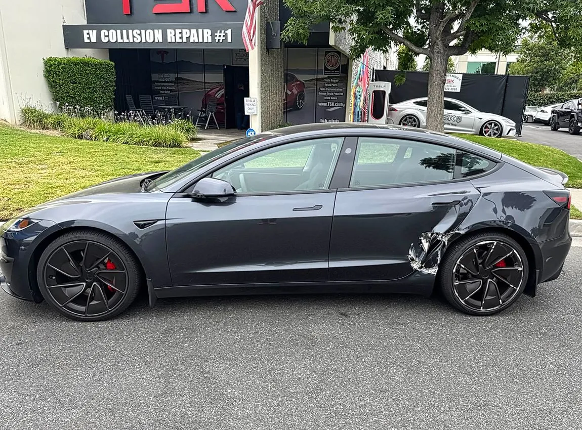 Gray Tesla Model 3 with rear quarter panel damage parked outside TSK EV Collision Repair