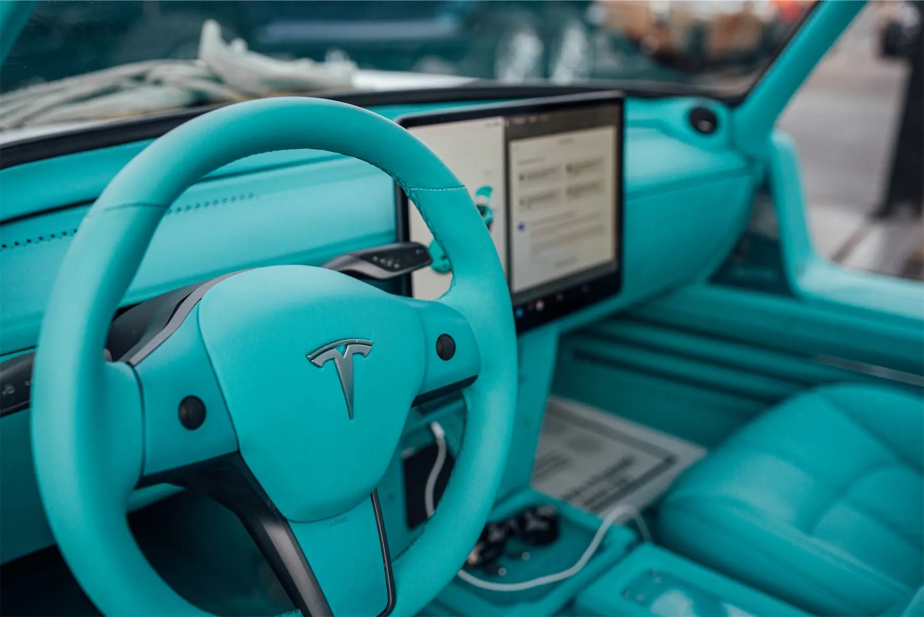 Tesla Gullwing project: teal-wrapped Tesla steering wheel and dashboard touchscreen