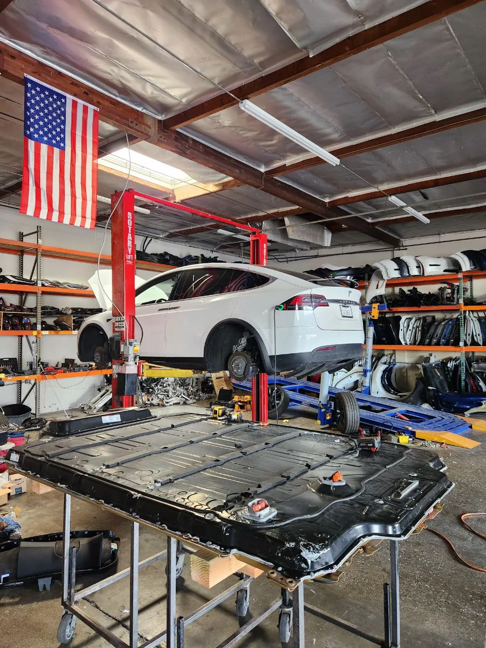 Tesla Model X on lift with removed HV battery pack at TSK Cypress shop