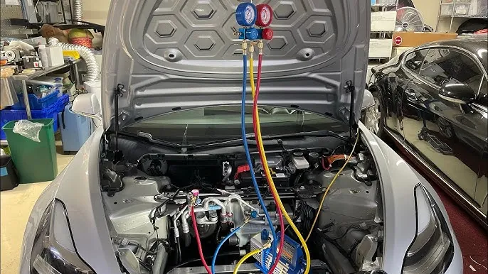 Manifold gauge set connected to EV air conditioning system during refrigerant recharge at TSK