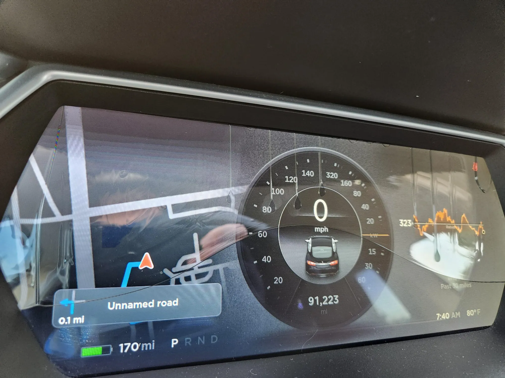 Tesla instrument cluster screen with cracked, water-leaking display showing speedometer
