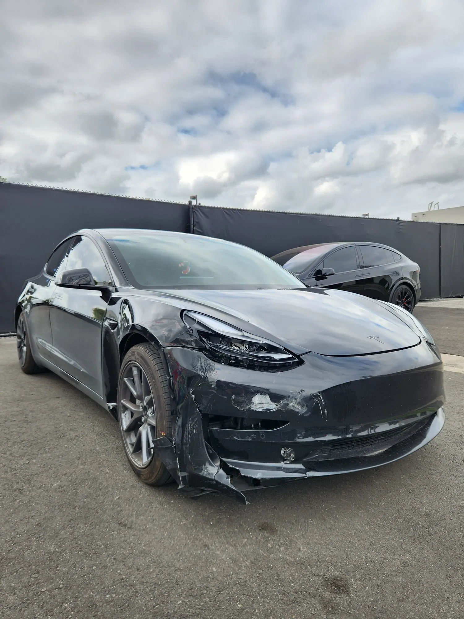 Black Tesla Model 3 with damaged front bumper before collision repair in Irvine