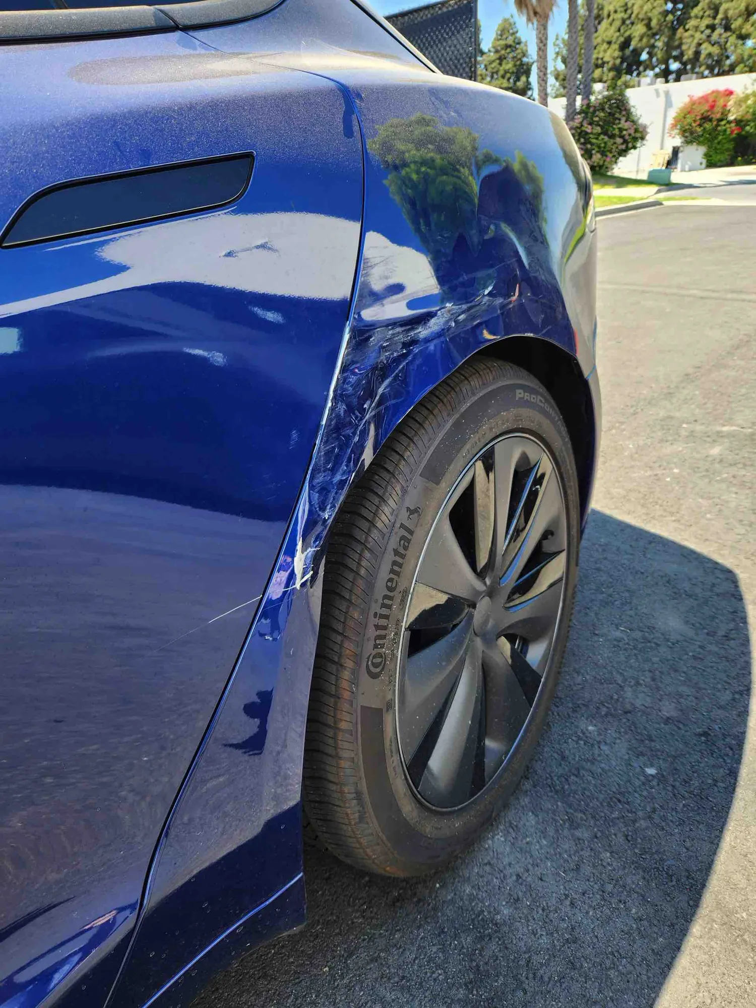 Blue Tesla Model 3 front fender scrape and dent before repair in Irvine