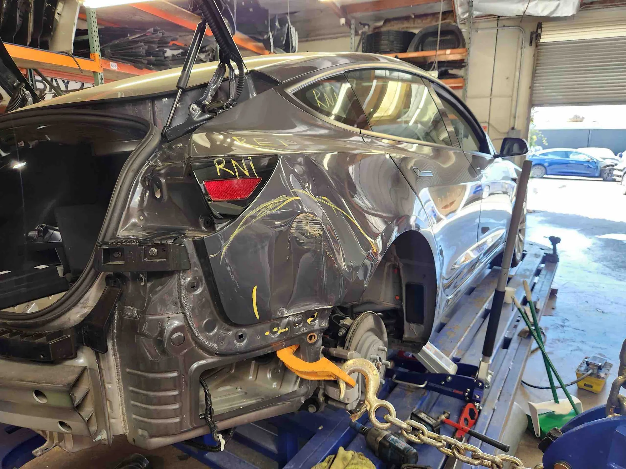 Tesla Model 3 rear quarter panel damage on frame machine at TSK Irvine shop