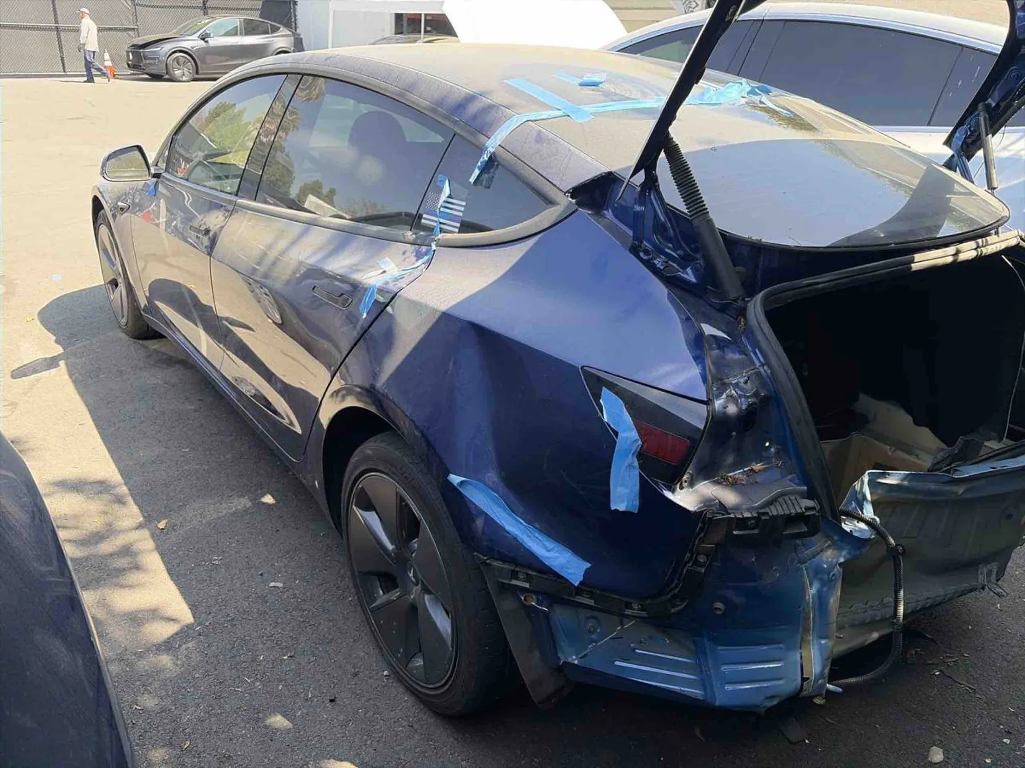 Blue Tesla Model 3 with severe rear-end collision damage before TSK repair