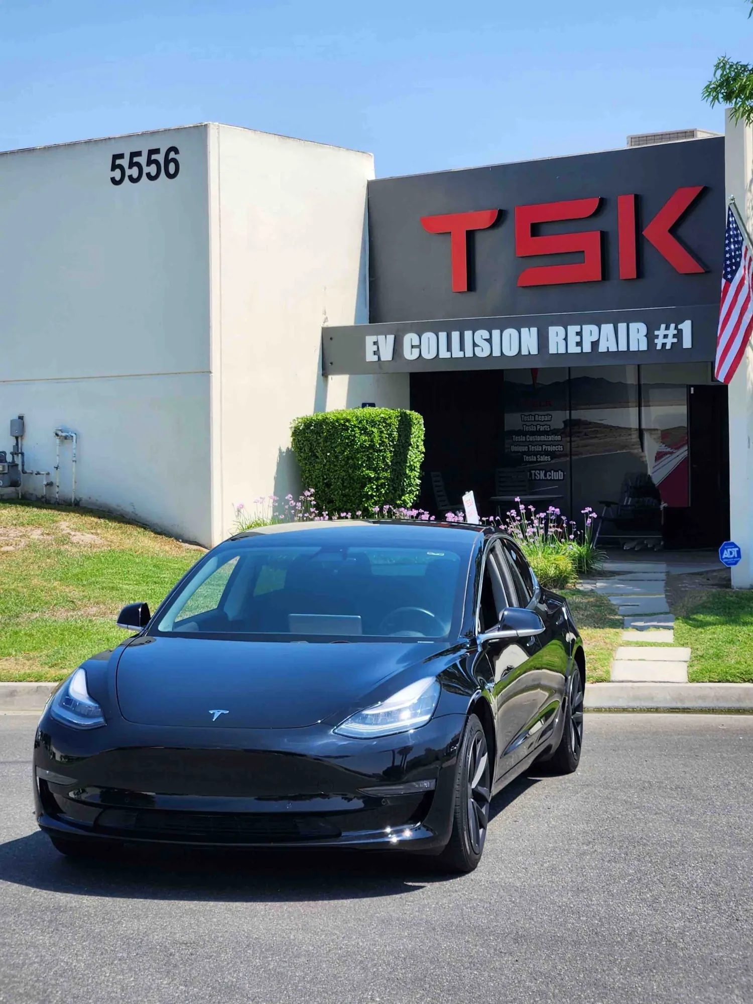 Black Tesla Model 3 parked outside TSK EV Collision Repair shop in Irvine