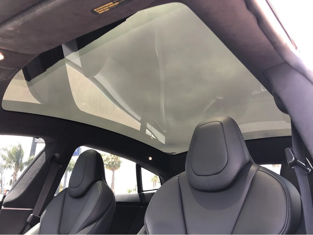 Tesla Model S interior showing black seats and panoramic glass roof