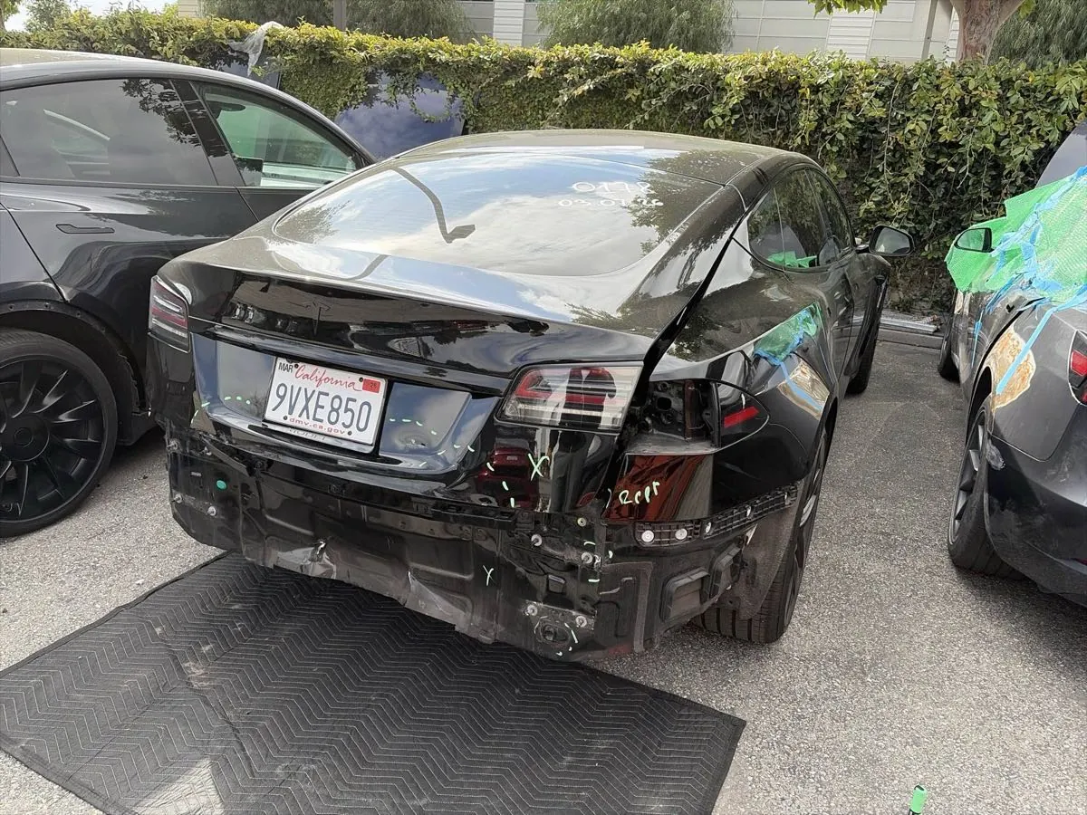 Black Tesla Model S with rear bumper removed during collision repair at TSK