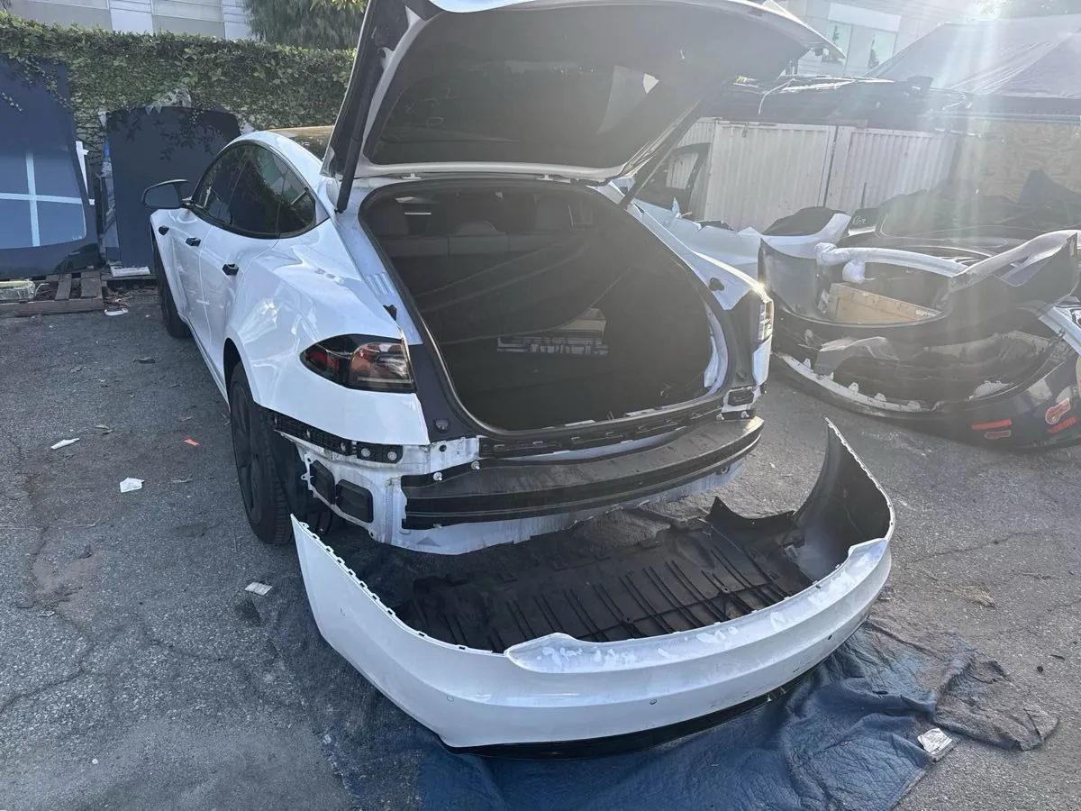 White Tesla Model S with rear bumper removed during collision repair at TSK Irvine