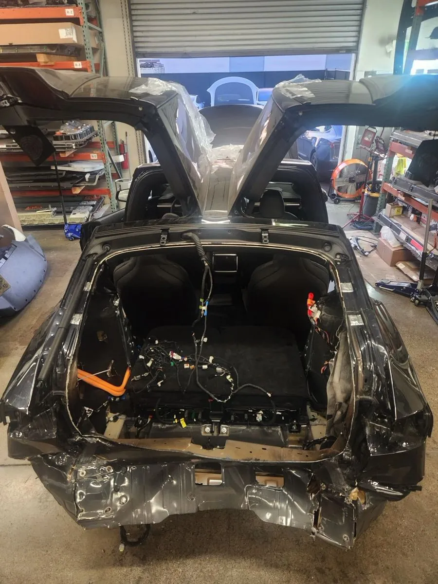 Tesla Model X rear frame exposed with wiring harness during collision repair at TSK