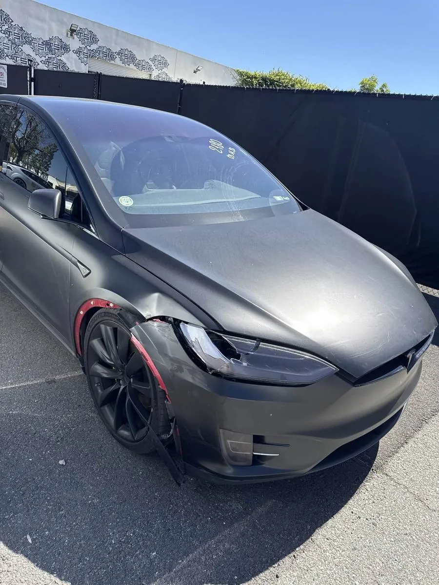 Damaged Tesla Model X with broken front bumper and headlight before repair at TSK Irvine