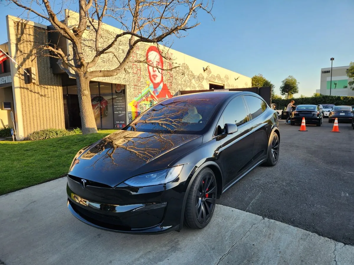 Black Tesla Model X parked outside TSK EV collision repair shop in Irvine