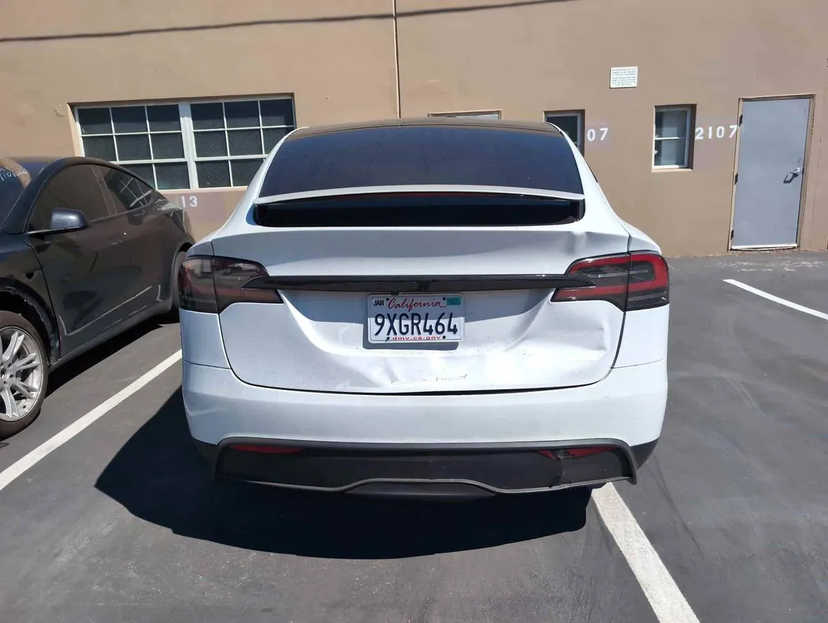 White Tesla Model X with dented rear bumper before trunk repair at TSK Irvine