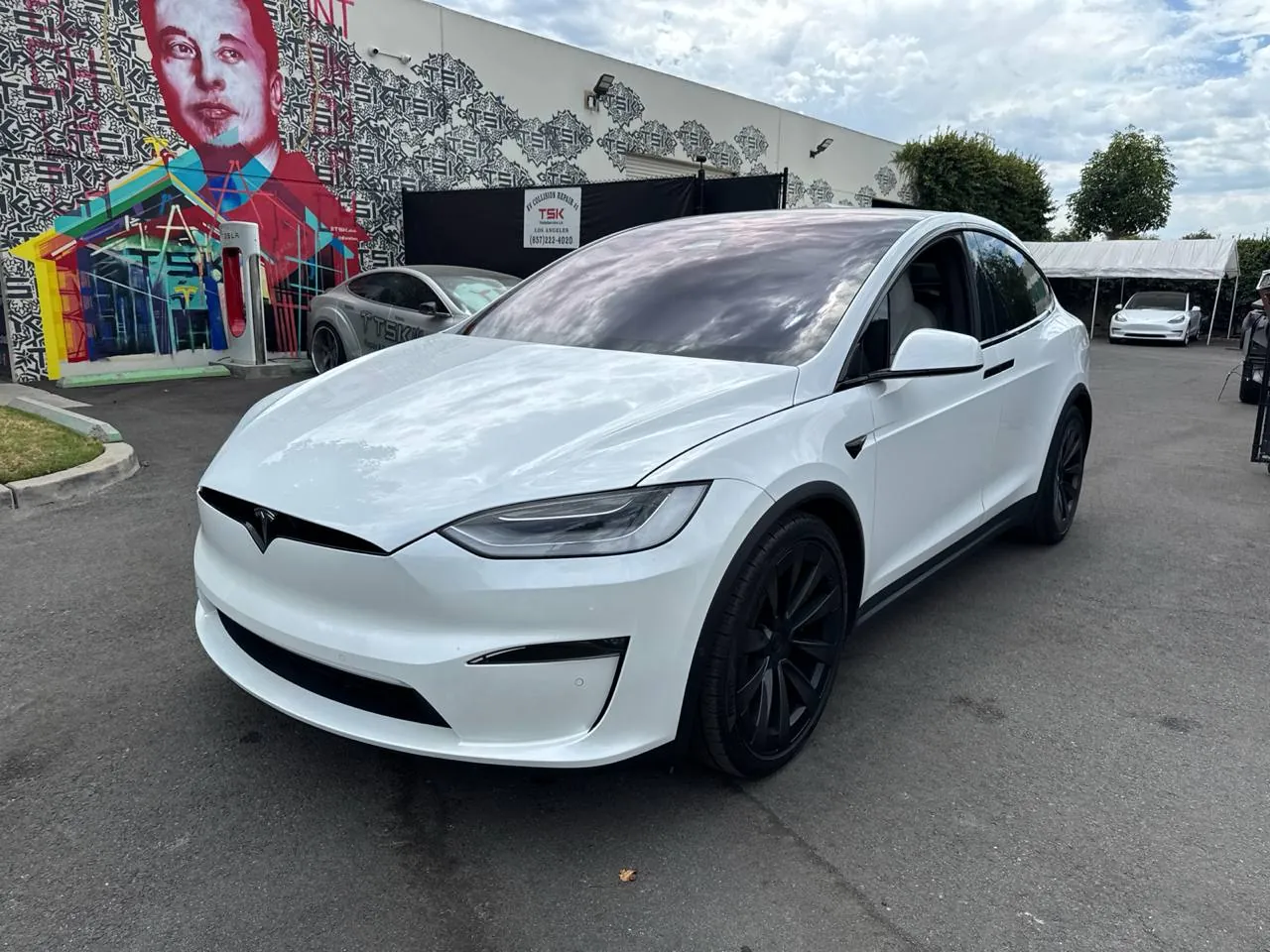 White Tesla Model X parked outside TSK's EV collision repair shop in Irvine