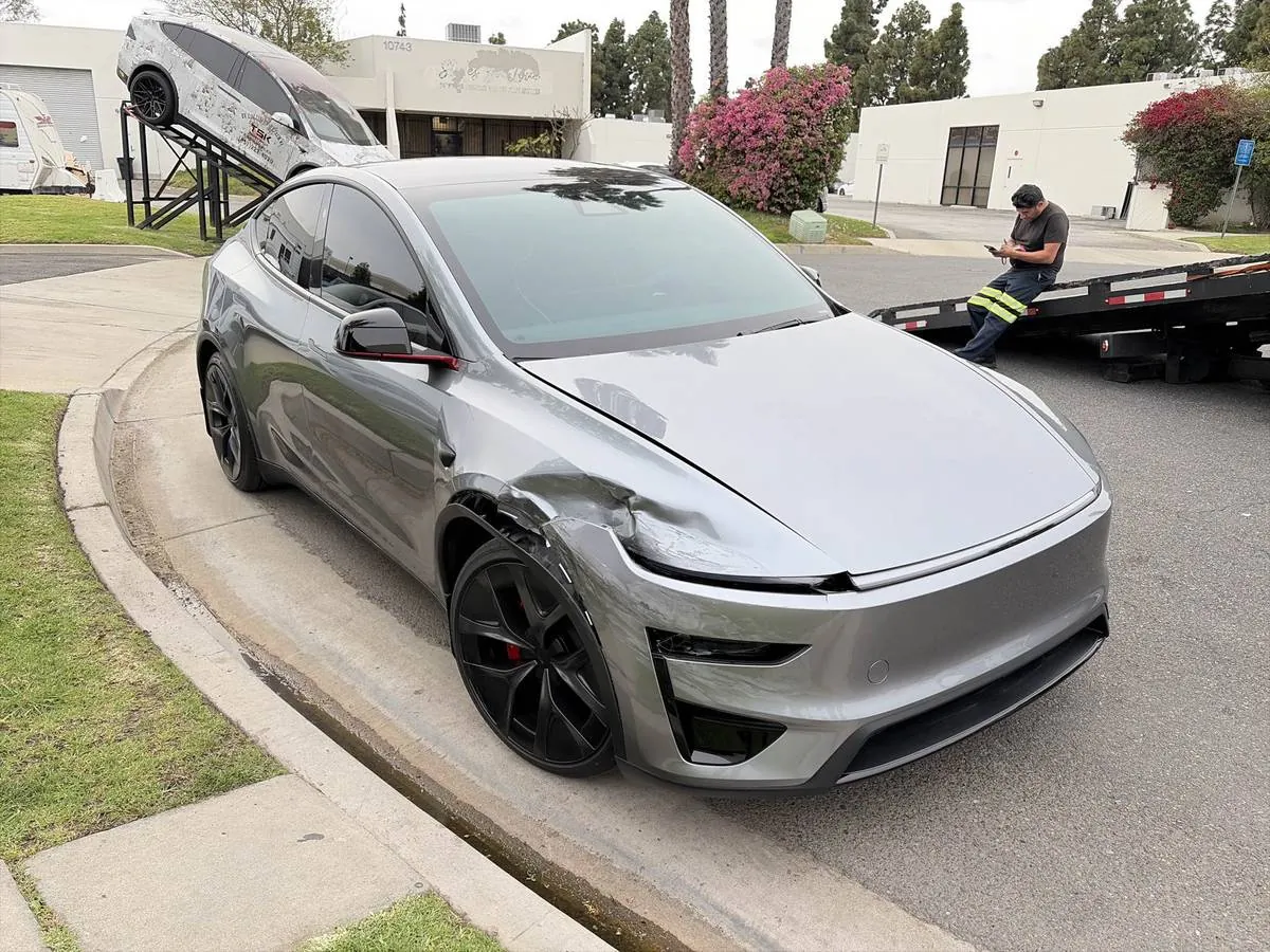 Silver Tesla Model Y with front fender damage arriving at TSK Irvine collision repair shop
