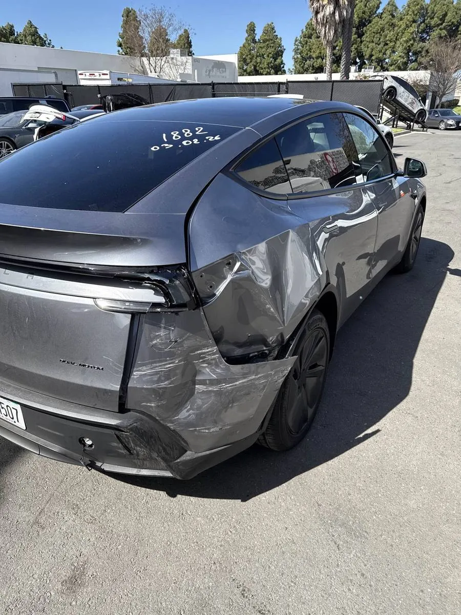 Gray Tesla Model Y with crumpled rear quarter panel damage before repair at TSK Irvine