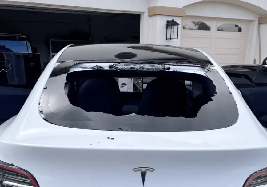 White Tesla Model Y with shattered rear glass before repair at TSK Irvine collision shop
