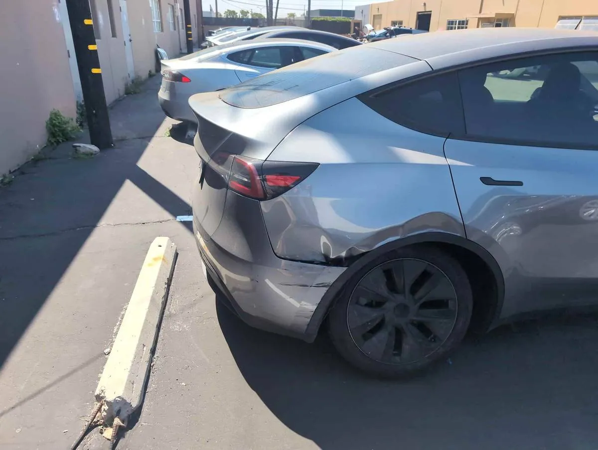 Silver Tesla Model Y with rear bumper damage before collision repair at TSK Irvine