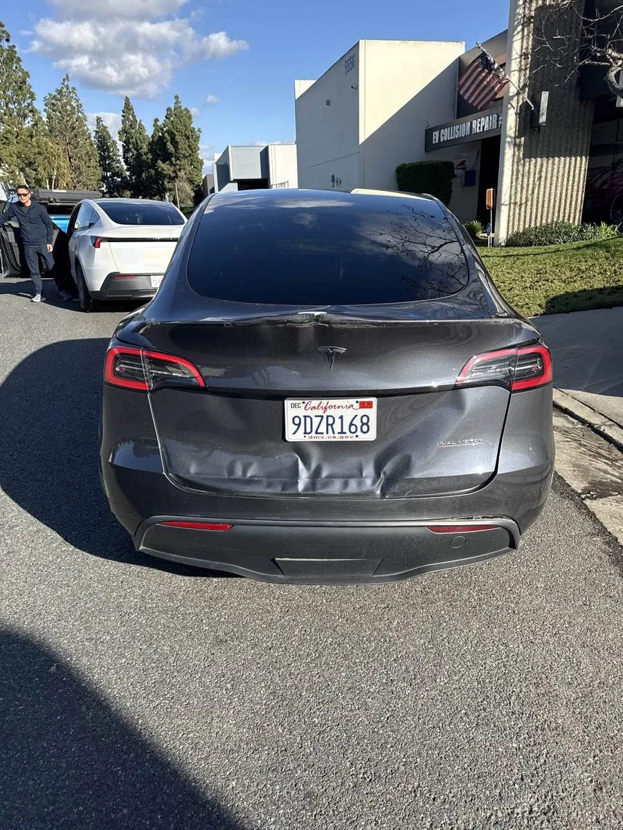 Gray Tesla Model Y with rear bumper damage at TSK collision repair shop in Irvine