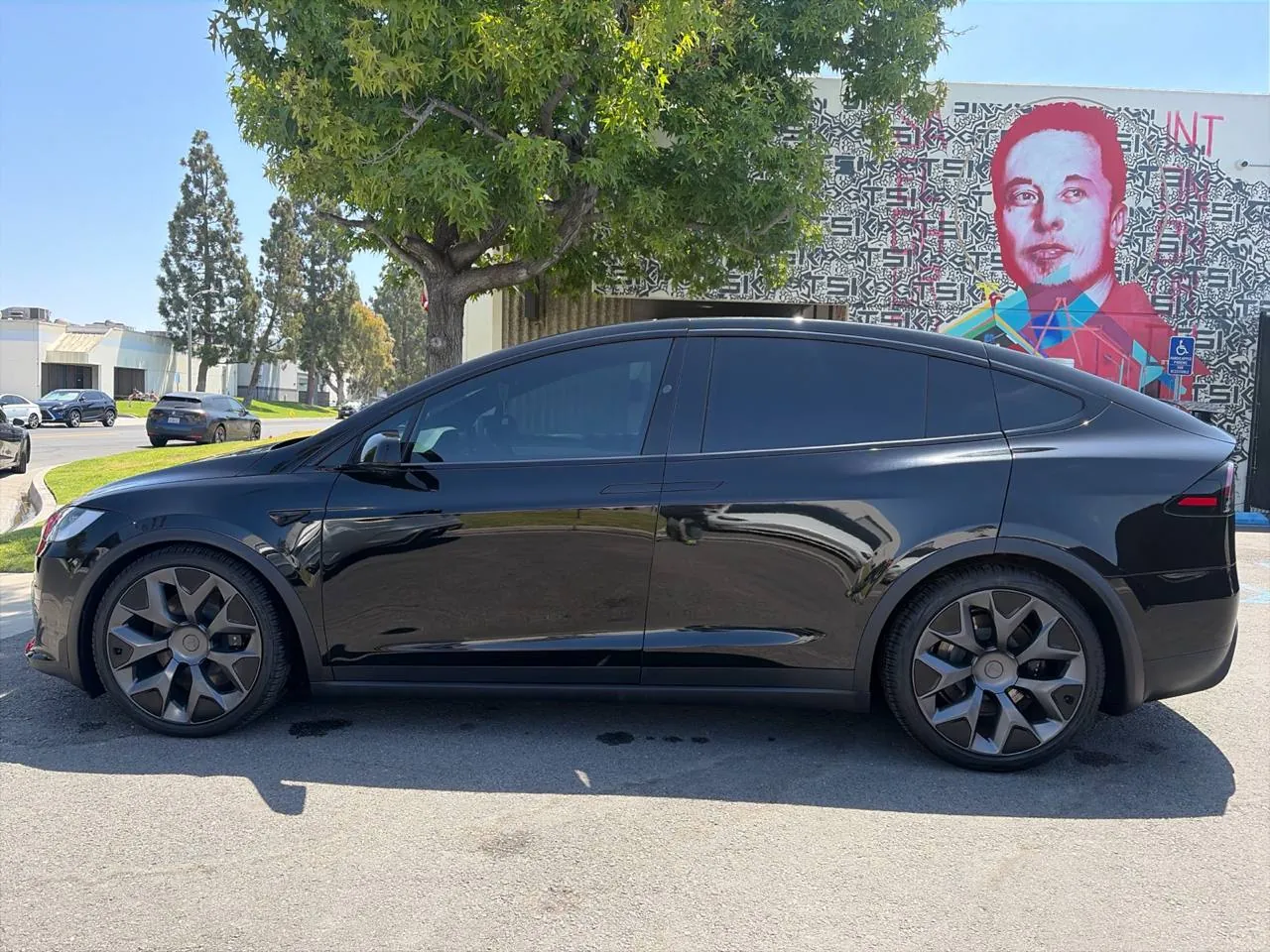 Black Tesla Model X parked outside TSK's Cypress collision repair and body shop