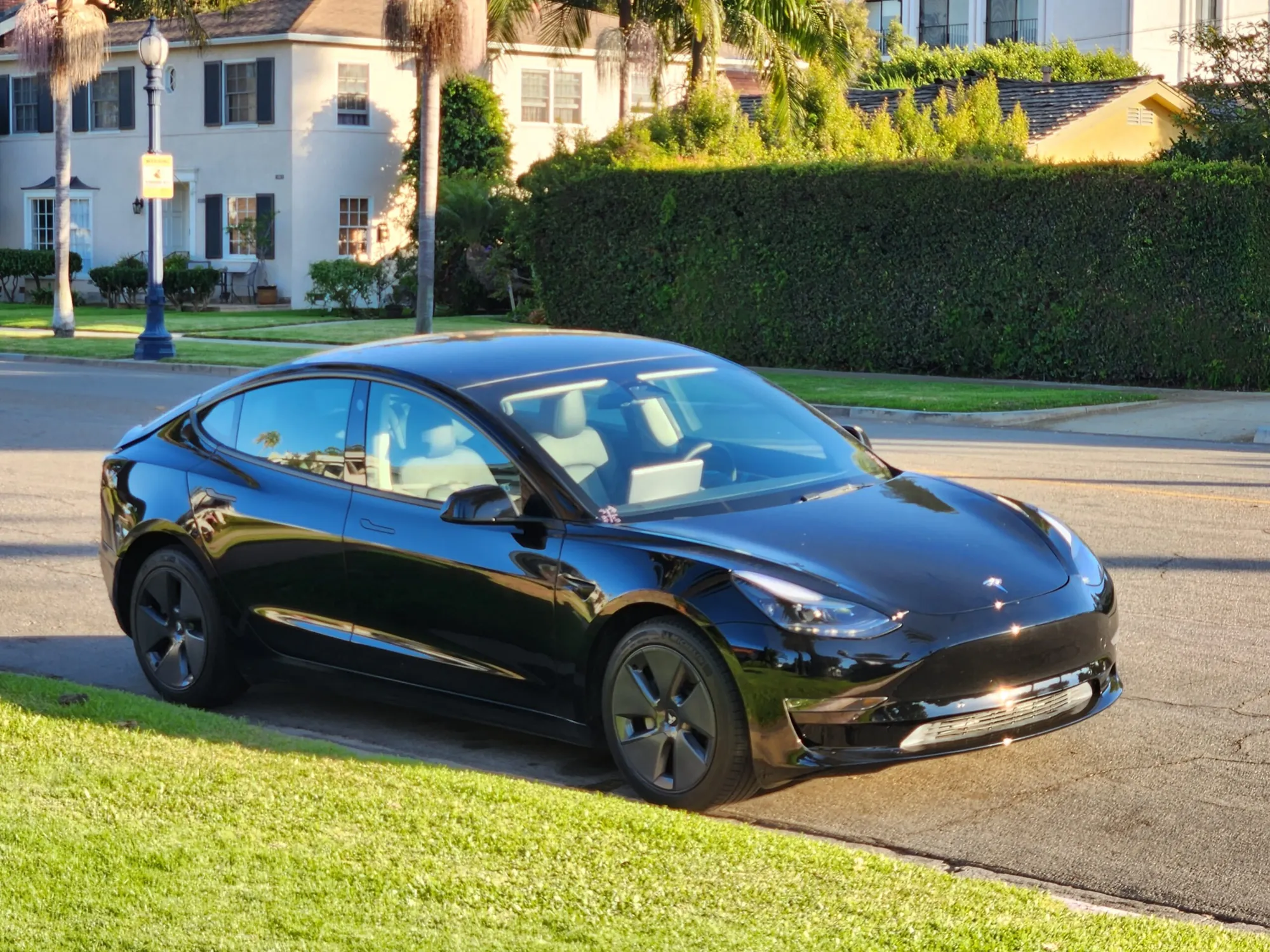 Black Tesla Model 3 parked on residential street after body repair at TSK