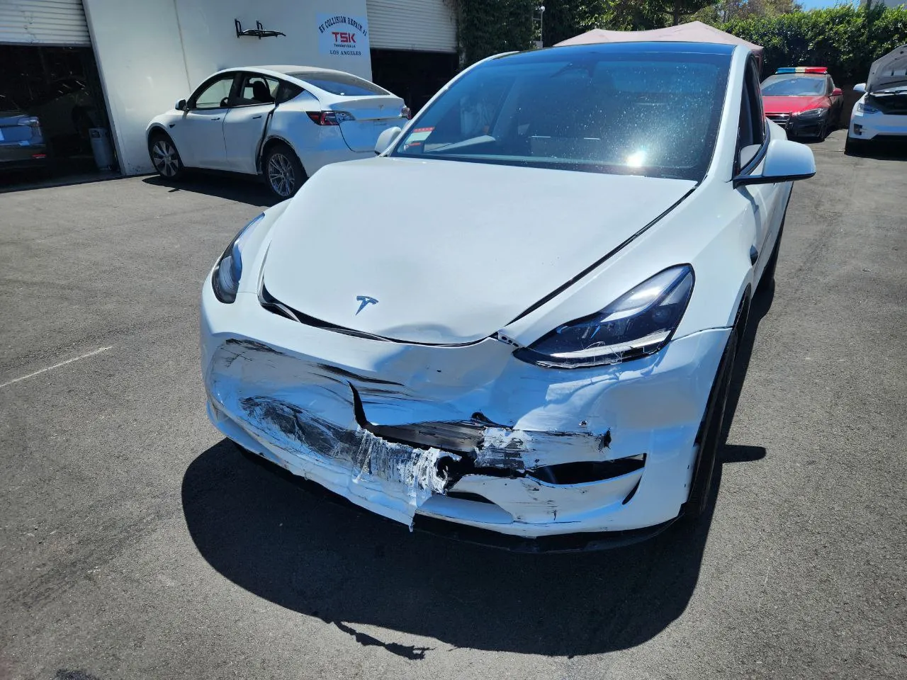White Tesla Model 3 with damaged front bumper before repair at TSK collision shop