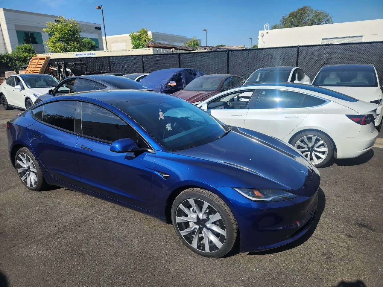 Blue Tesla Model 3 parked in lot after body repair at TSK collision shop