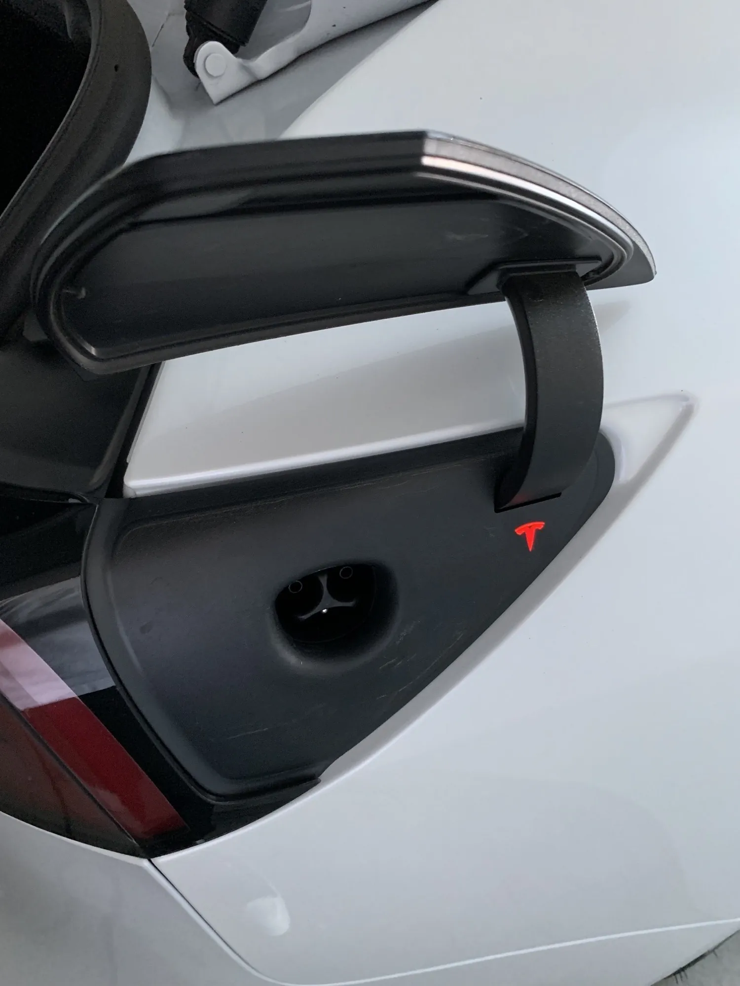 Tesla Model 3 charge port open with illuminated red ring indicating charging fault