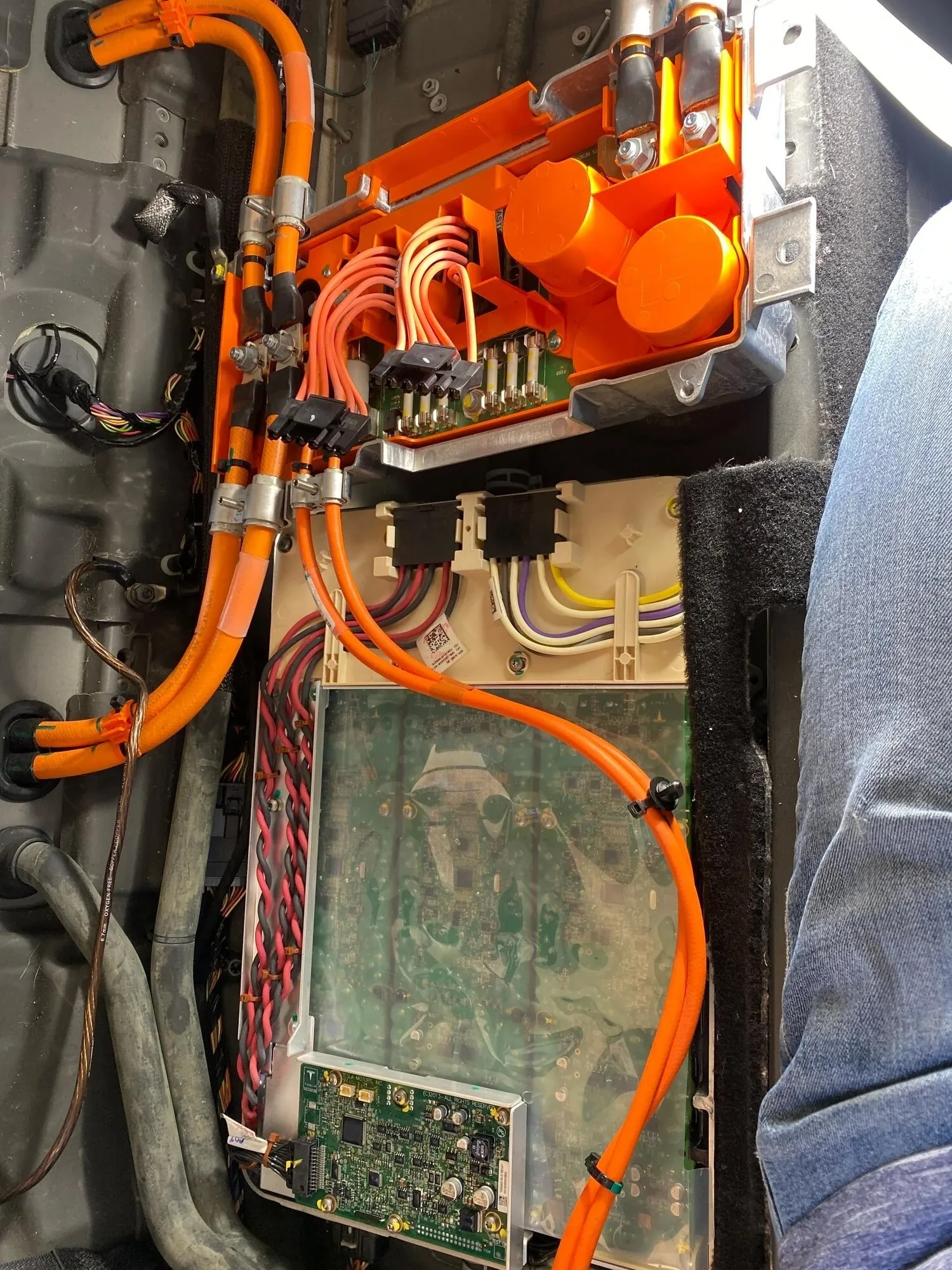 Tesla Model 3 onboard charger and high-voltage cables exposed during troubleshooting at TSK