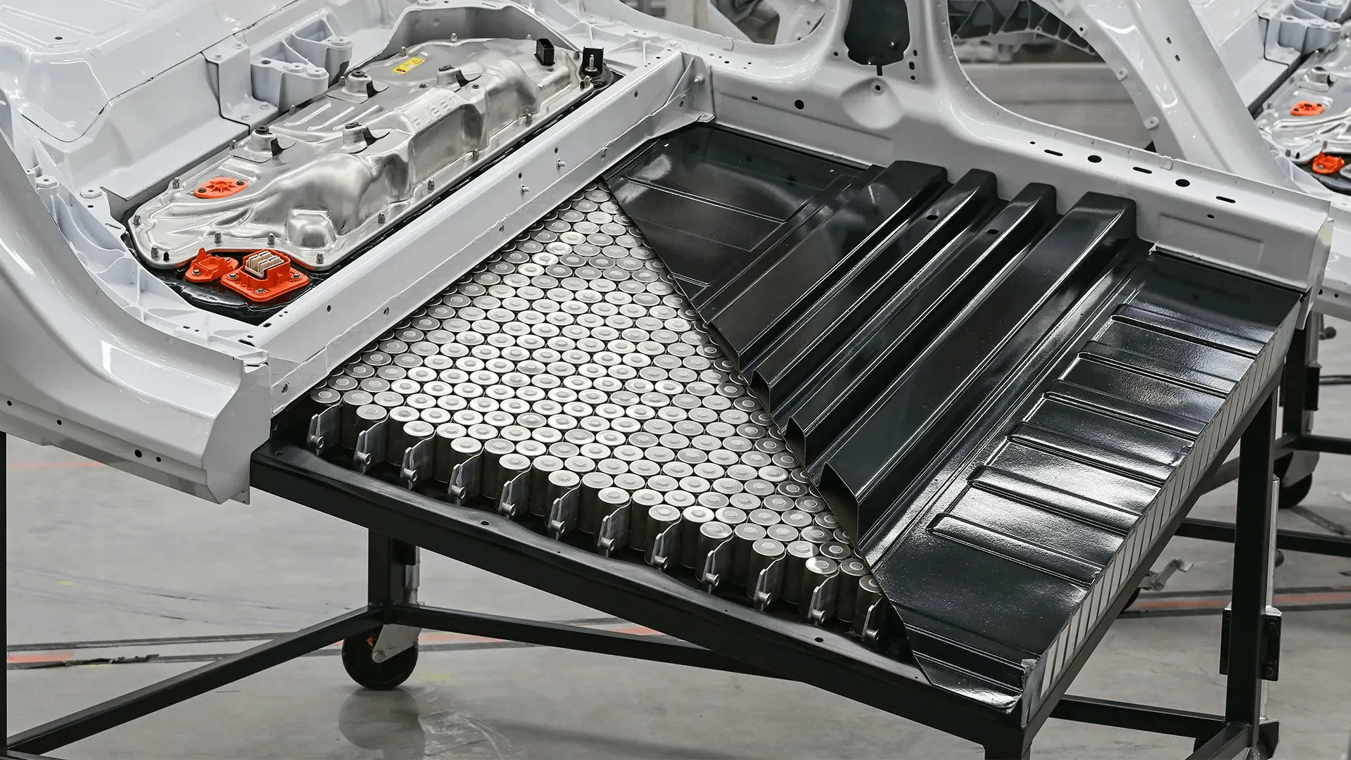 Tesla Model 3 underbody showing exposed cylindrical cells inside high-voltage battery pack