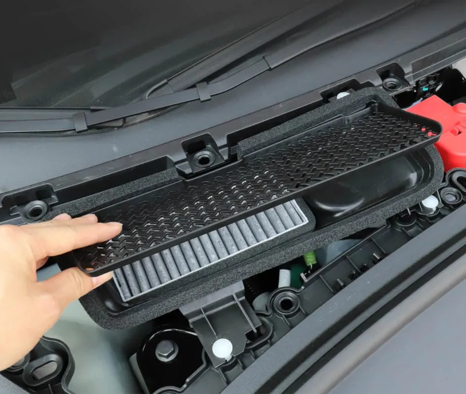 Technician removing Tesla Model 3 cabin air filter during HVAC service at TSK