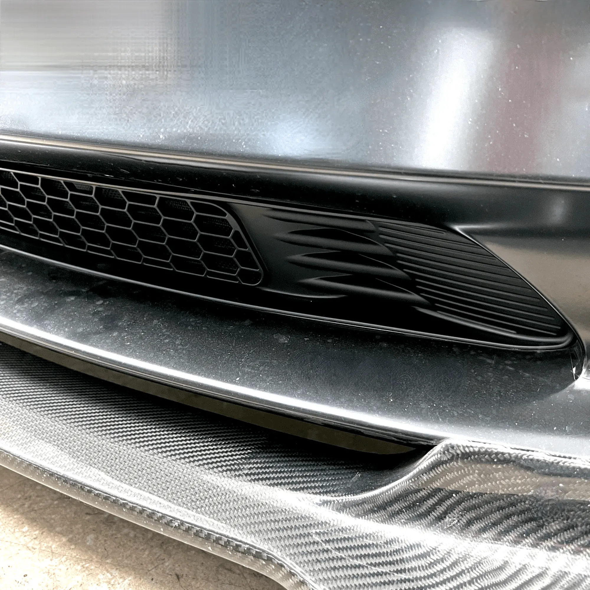 Close-up of Tesla Model 3 front bumper louvers and grille before HVAC service