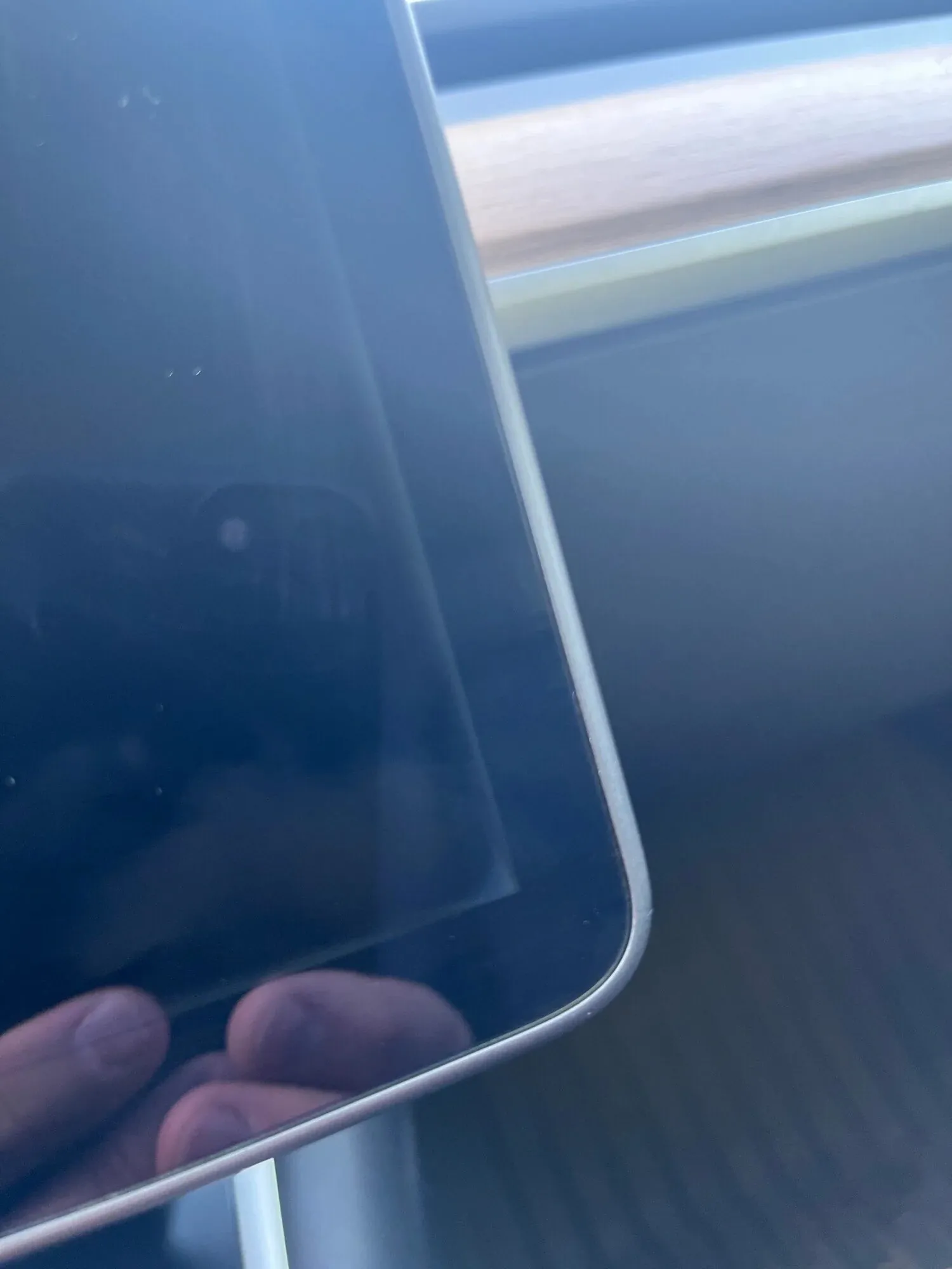 Close-up of Tesla Model 3 center touchscreen edge showing separation from bezel
