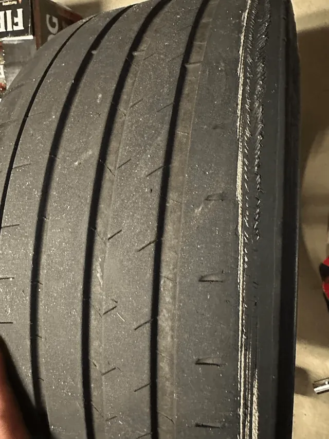 Worn Tesla Model 3 tire showing edge wear from misaligned rear suspension