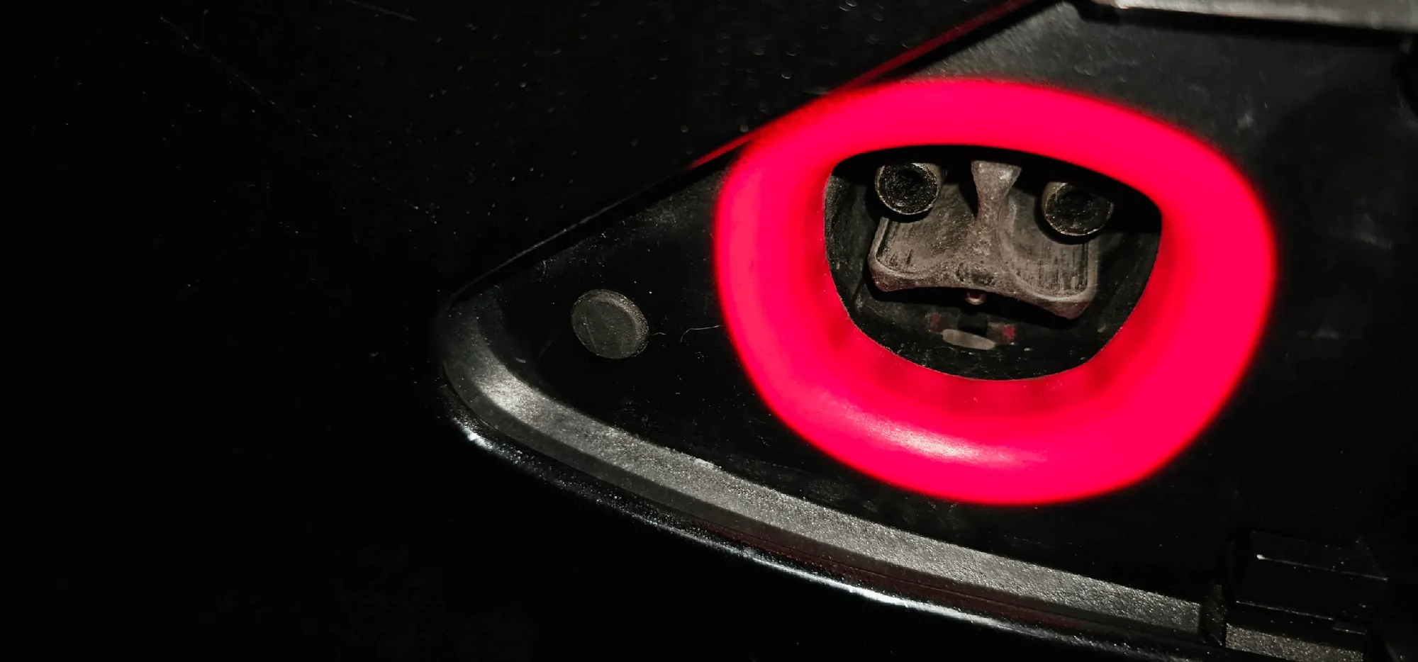 Tesla Model S charge port glowing red, indicating a charging system fault