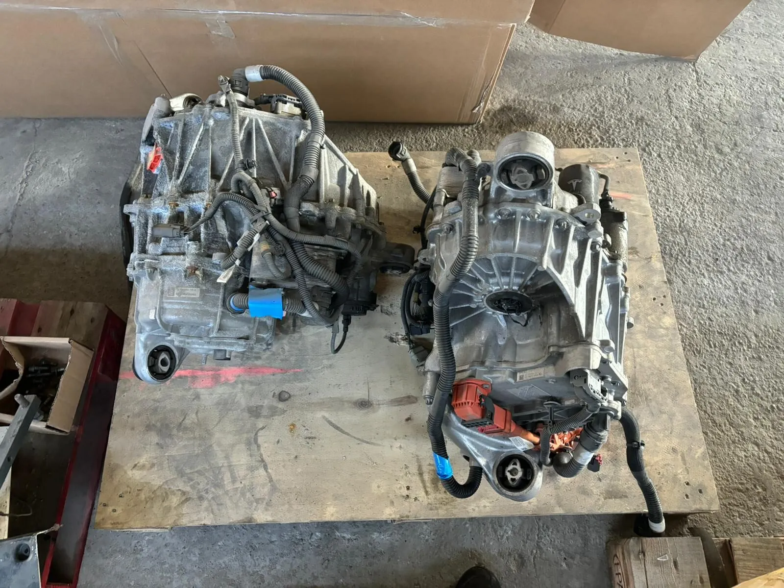 Two Tesla Model S drive units on wooden pallet before bearing replacement service