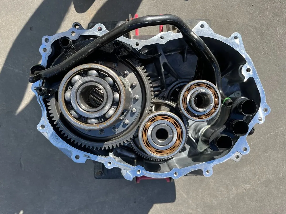 Open Tesla Model S drive unit housing showing reduction gear and bearings during repair