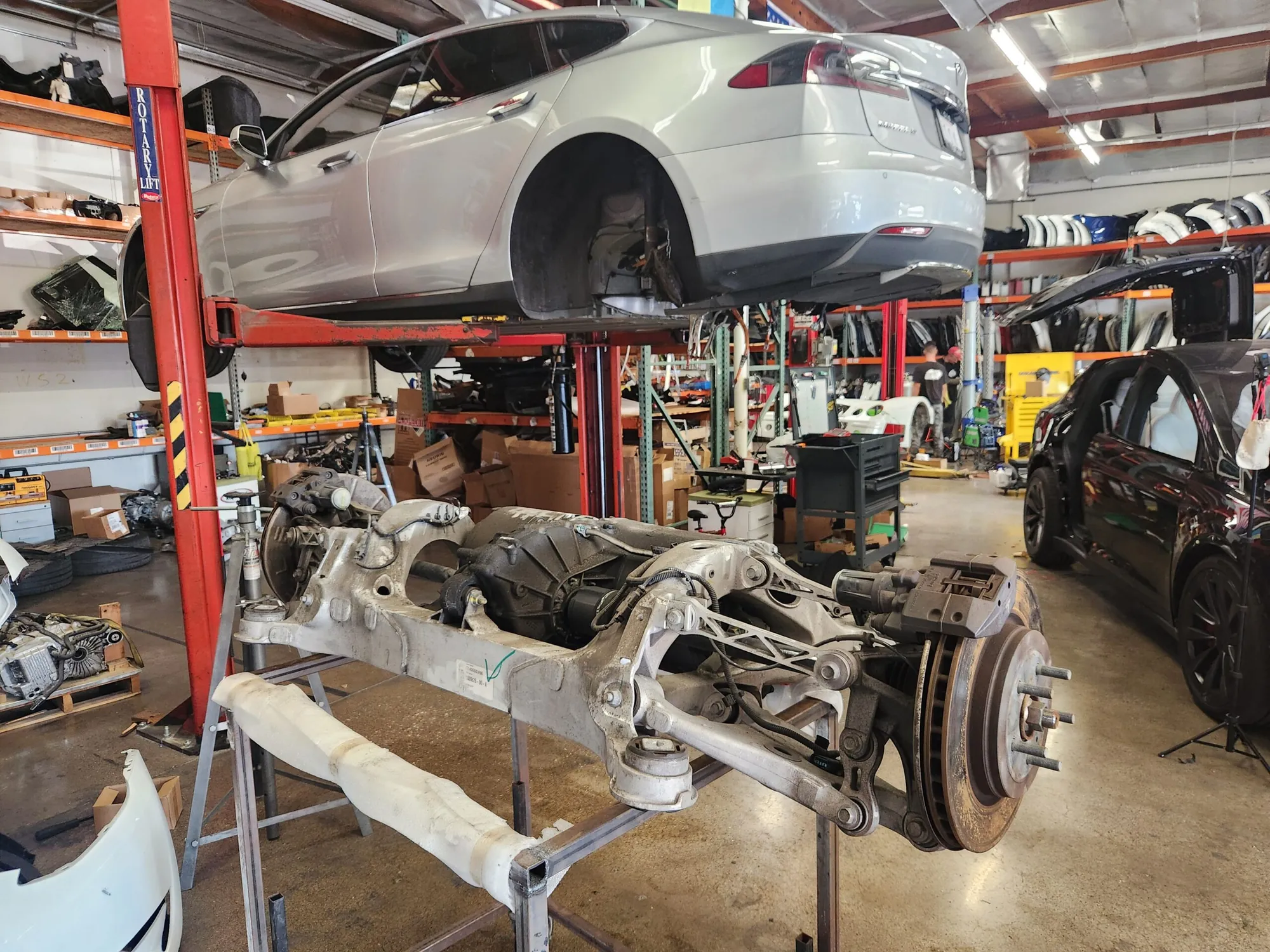 Tesla Model S rear drive unit removed, on lift at TSK repair shop
