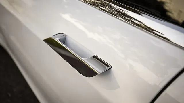 Close-up of Tesla Model S chrome door handle on white exterior panel